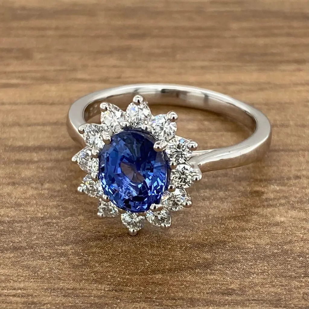 Diamond halo engagement ring with sapphire center stone.