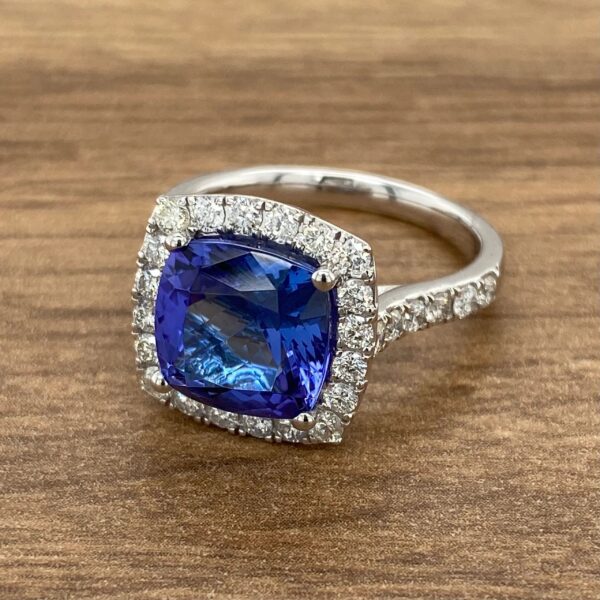 Diamond halo ring with blue gemstone.