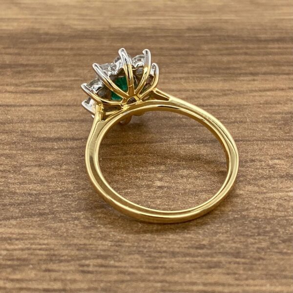 Gold ring with emerald and diamond stones.