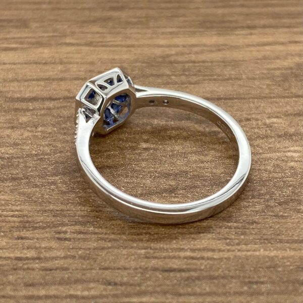 Blue sapphire engagement ring on wood background.