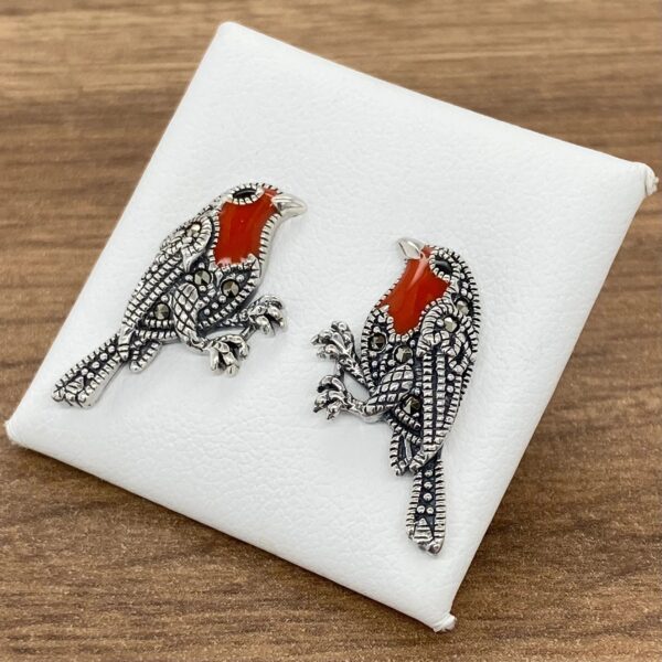 Silver bird earrings with red accents.