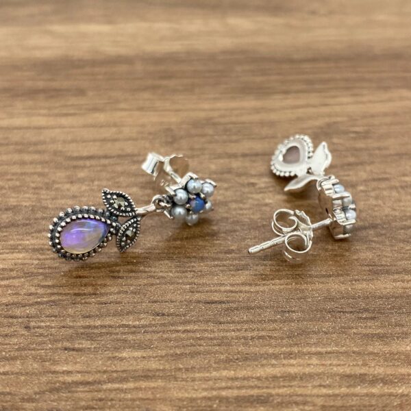 Silver earrings with opal and pearl accents.