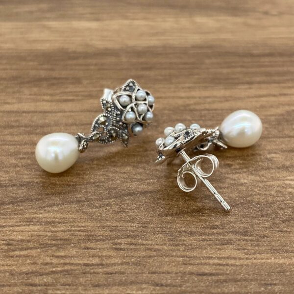 Silver pearl earrings with marquetry detail.