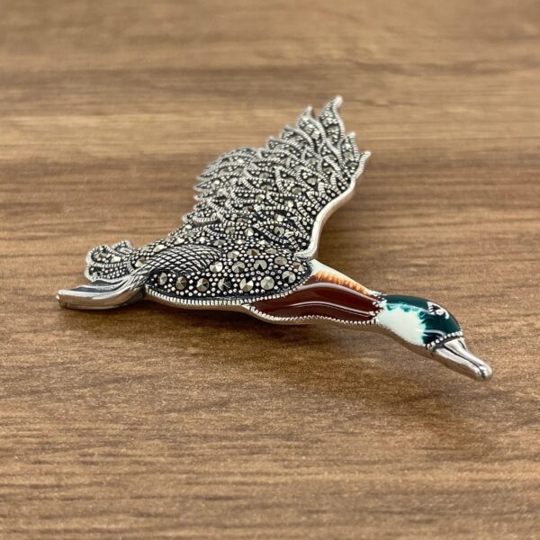 Silver and enamel flying duck brooch.