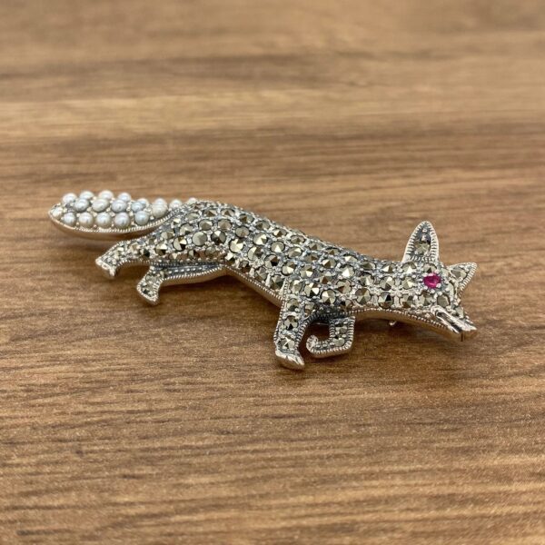 Silver fox brooch with pearl tail and red eyes.