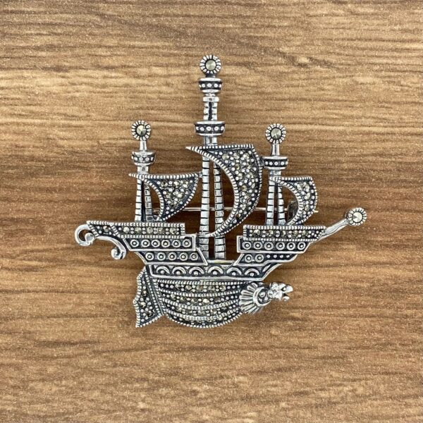 Silver ship brooch with marcasite details.