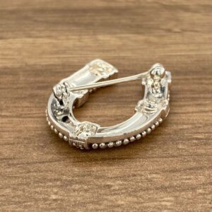 A horseshoe brooch with pearls and crystals.