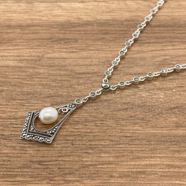 Silver necklace with a pearl pendant.