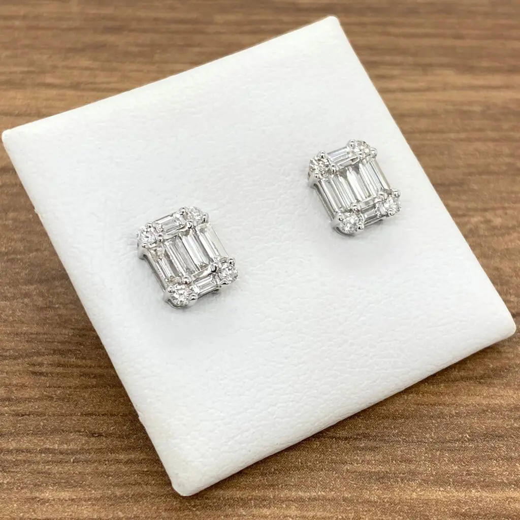 Diamond stud earrings on white display.