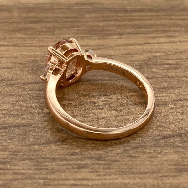 Rose gold ring with oval gemstone.