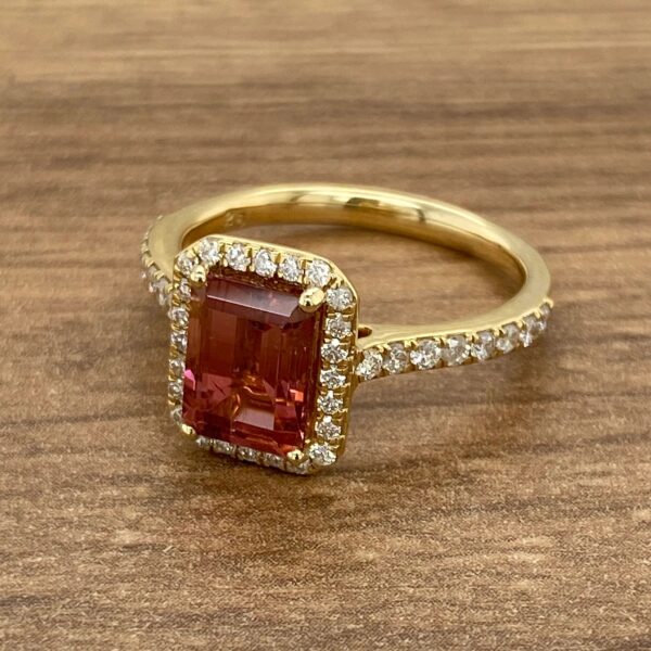 Gold ring with pink gemstone and diamonds.