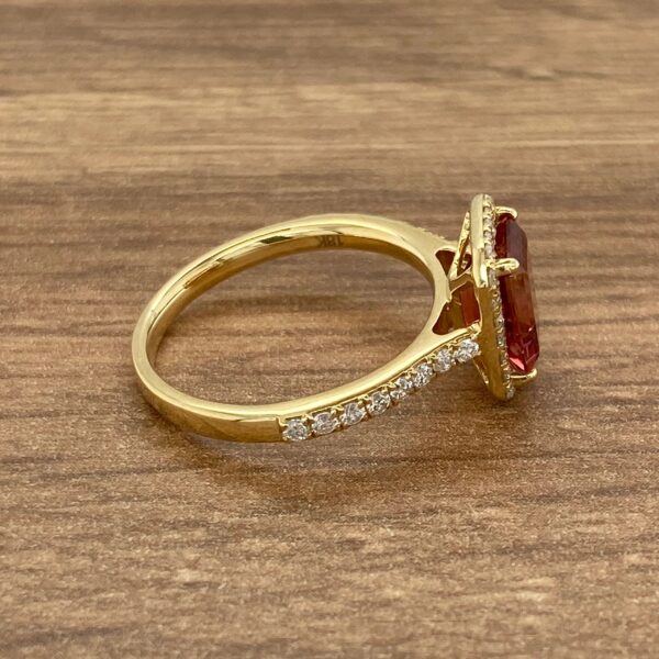 Gold ring with red gemstone and diamonds.