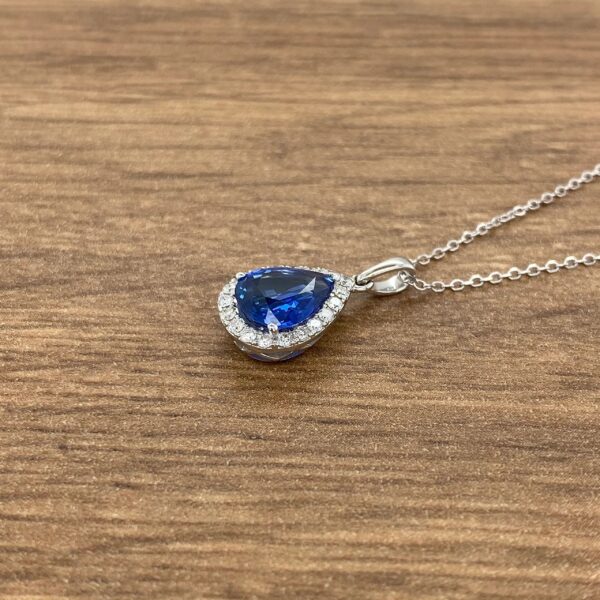 Pear-shaped sapphire pendant with diamond halo.