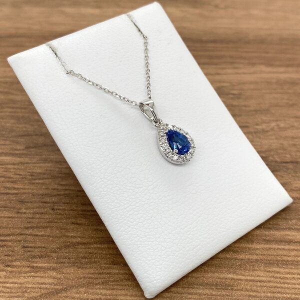 Pear-shaped sapphire pendant with diamond halo.