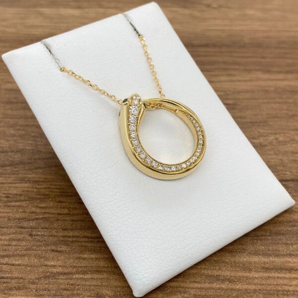 Gold necklace with diamond circle pendant.