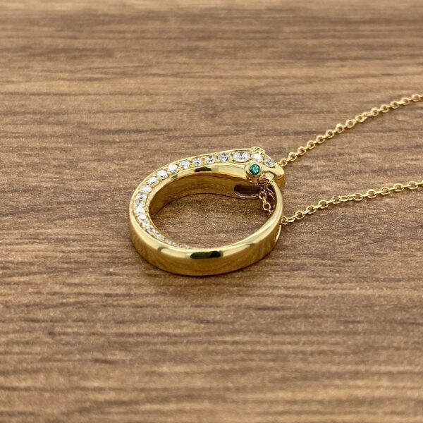 Gold snake necklace with green eyes.