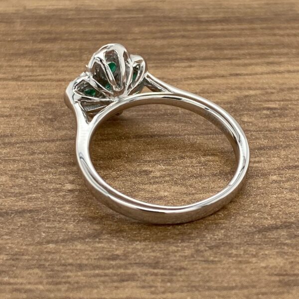 Silver ring with green gemstone setting.