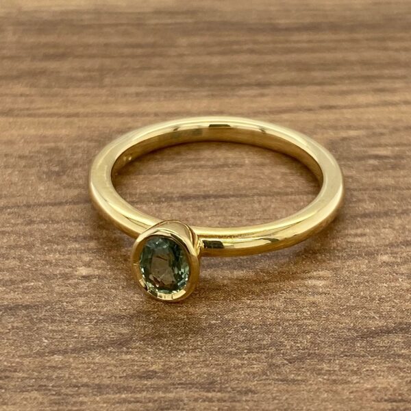 Gold ring with a green gemstone.