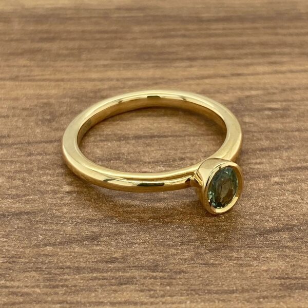 Gold ring with a green gemstone.