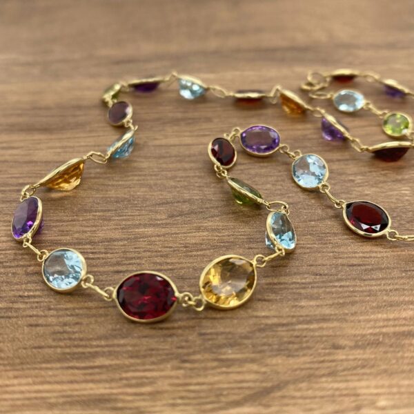 Multi-colored gemstone necklace on wood.