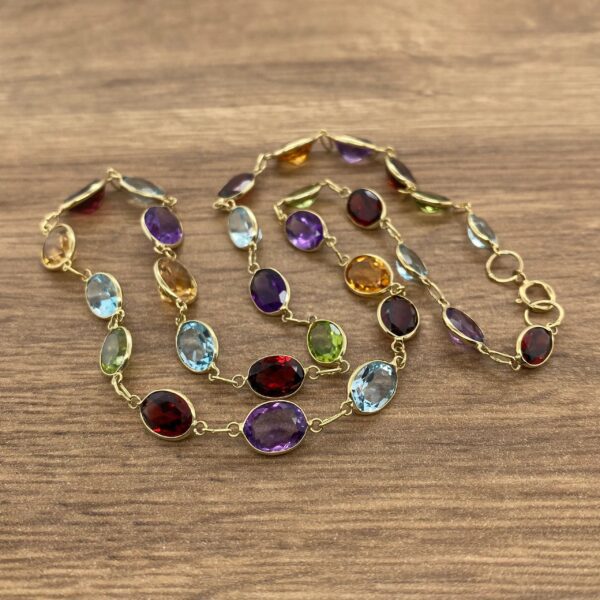 Gold chain with colorful gemstone links.