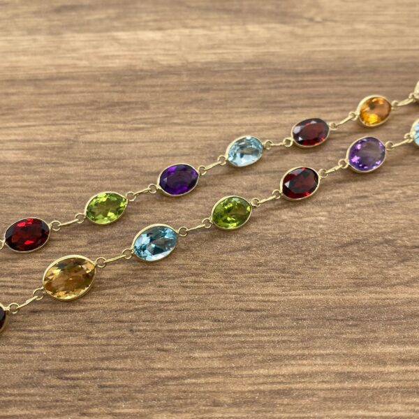 Gold chain with colorful gemstone links.