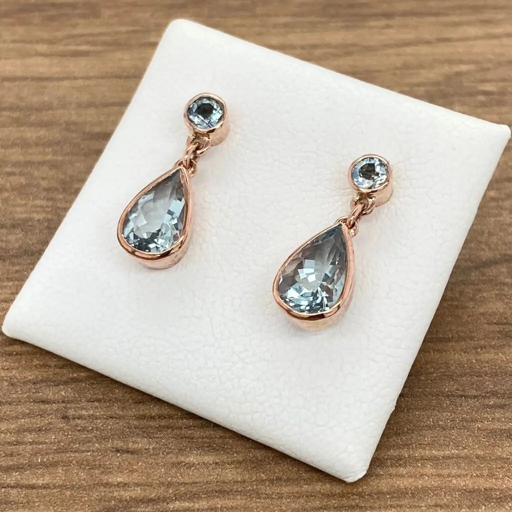 Rose gold earrings with teardrop aquamarine stones.