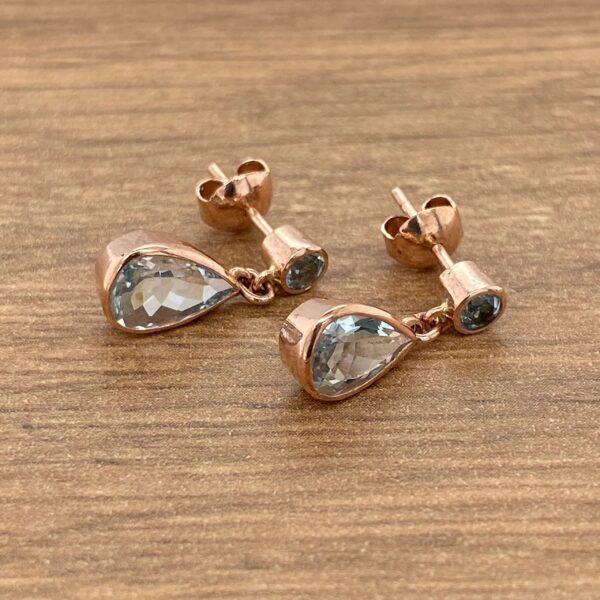 Rose gold teardrop earrings with aquamarine stones.