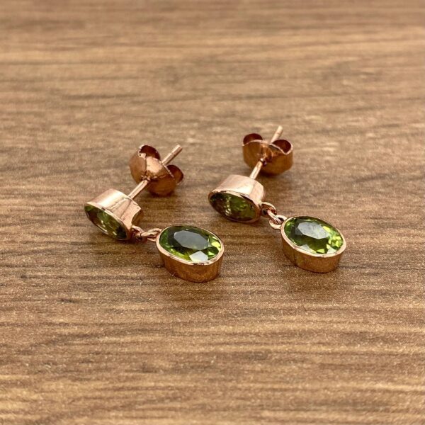 Rose gold earrings with green stones.