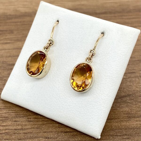 Gold earrings with oval citrine stones.