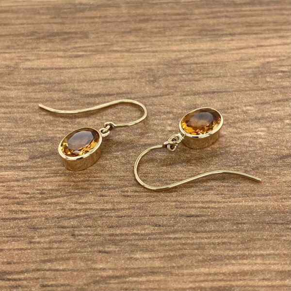 Gold earrings with oval citrine stones.