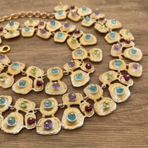 Gold necklace with multi-colored gemstones.