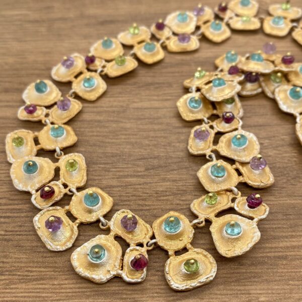 Gold necklace with colorful gemstones.