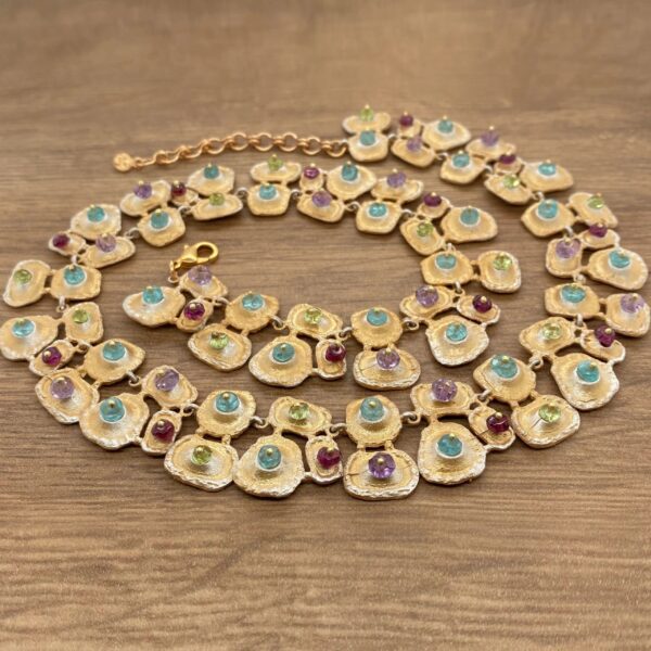 Gold necklace with colorful gemstones.