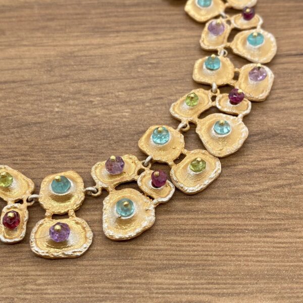 Gold necklace with colorful gemstones.