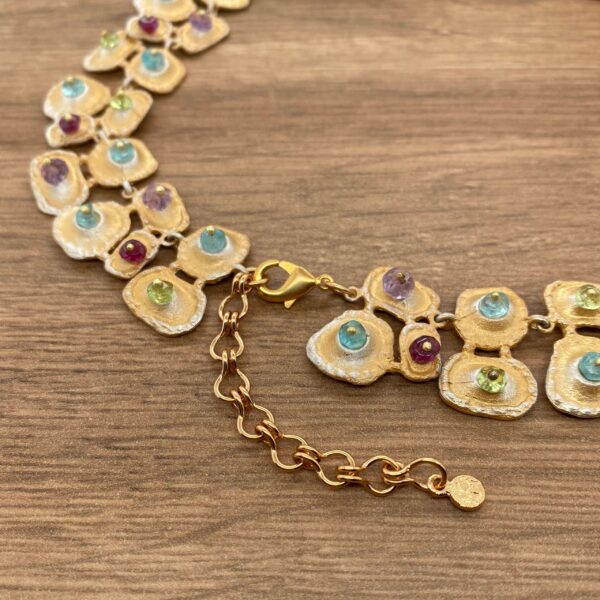 Gold necklace with colorful gemstones.