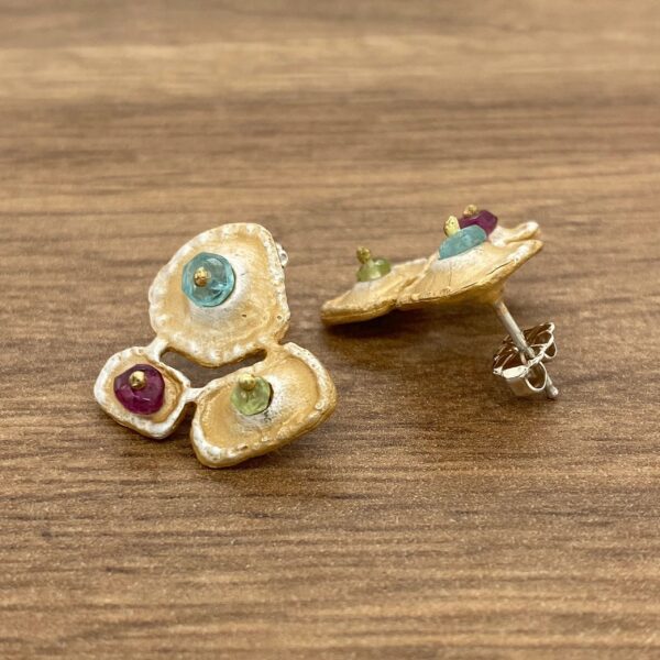 Gold earrings with colorful gemstones.