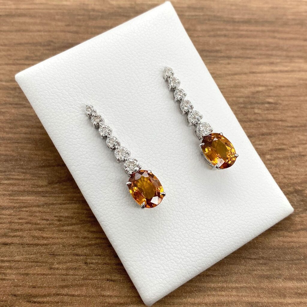 Orange gemstone and diamond earrings.