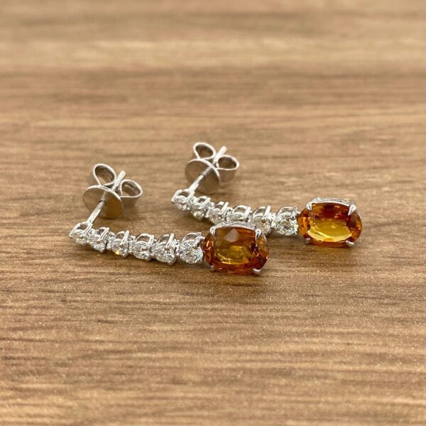 Diamond and orange sapphire earrings.