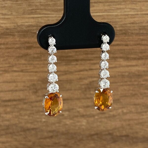 Orange gemstone and diamond earrings.