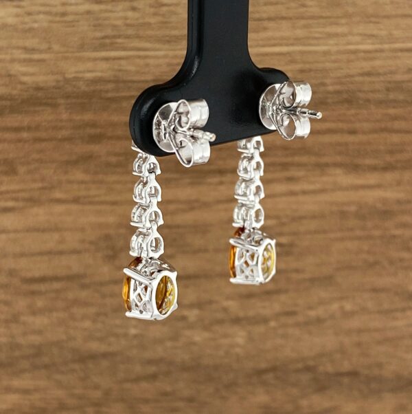 Silver earrings with yellow gemstones.