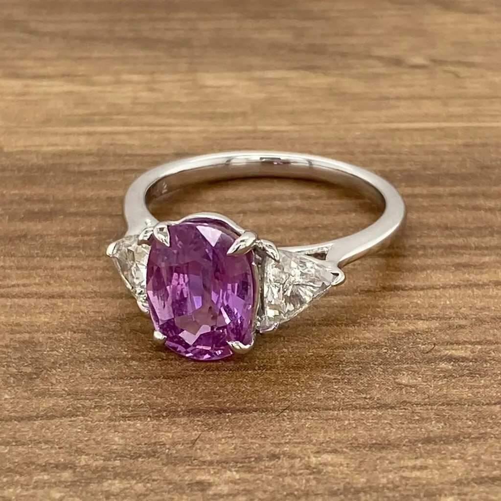 Oval purple sapphire engagement ring with diamonds.