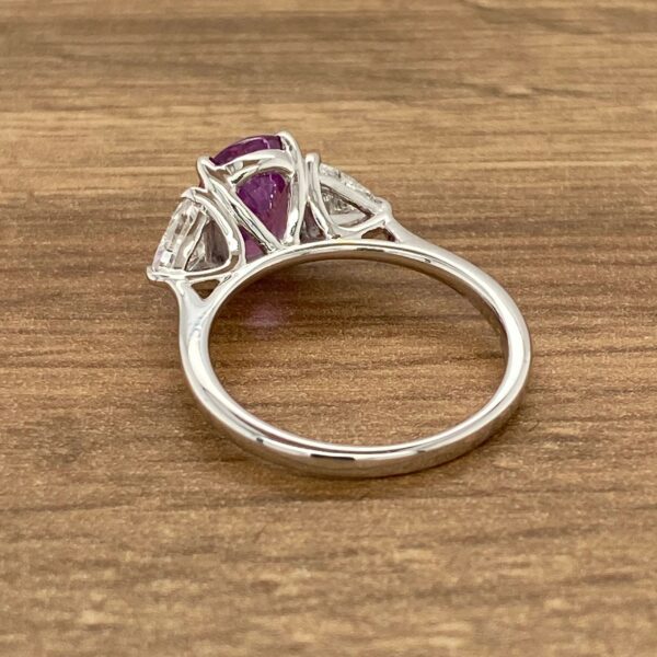 Three-stone purple sapphire engagement ring.