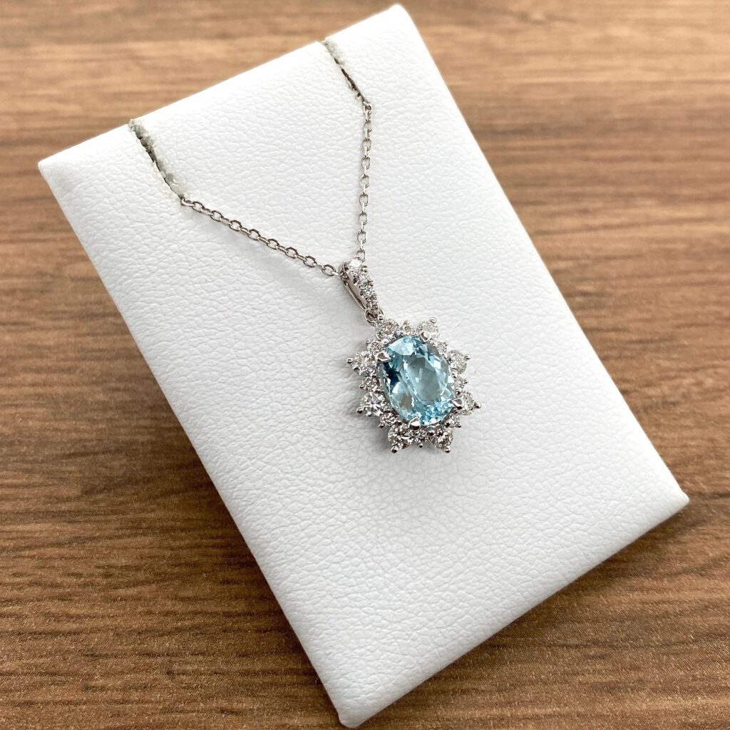 A necklace with a blue topaz and diamonds.