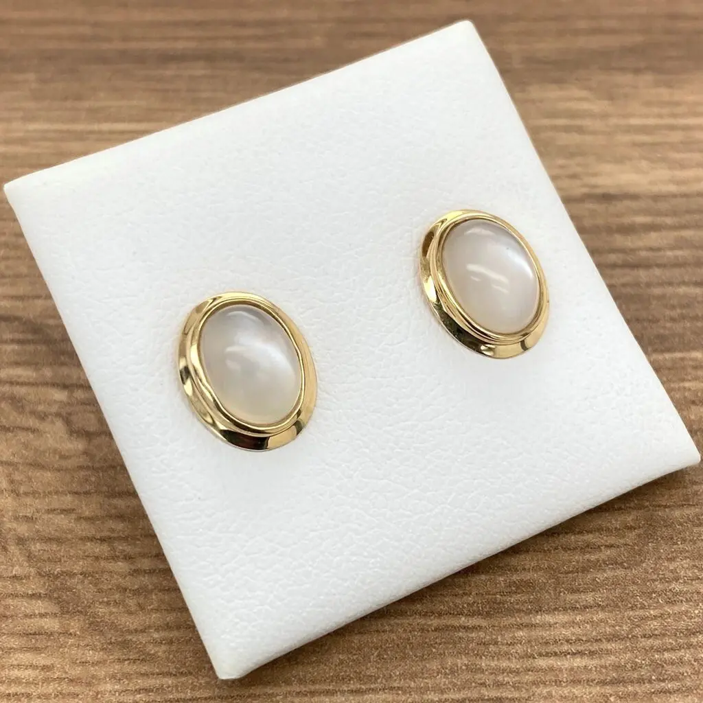 Gold earrings with white oval stones.