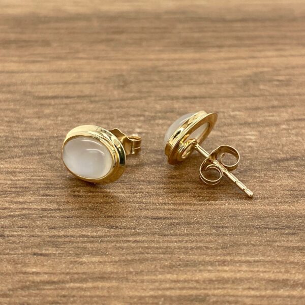 Gold oval earrings with white stones.