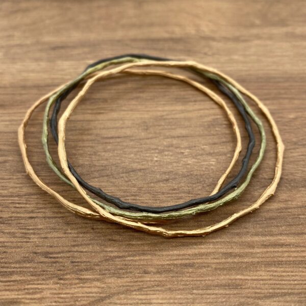 Gold, black, and green twig bangles.