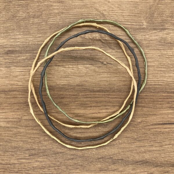 Three twig bangles on a wood background.