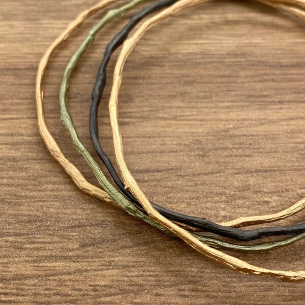 Gold, black, and green wire bracelets.