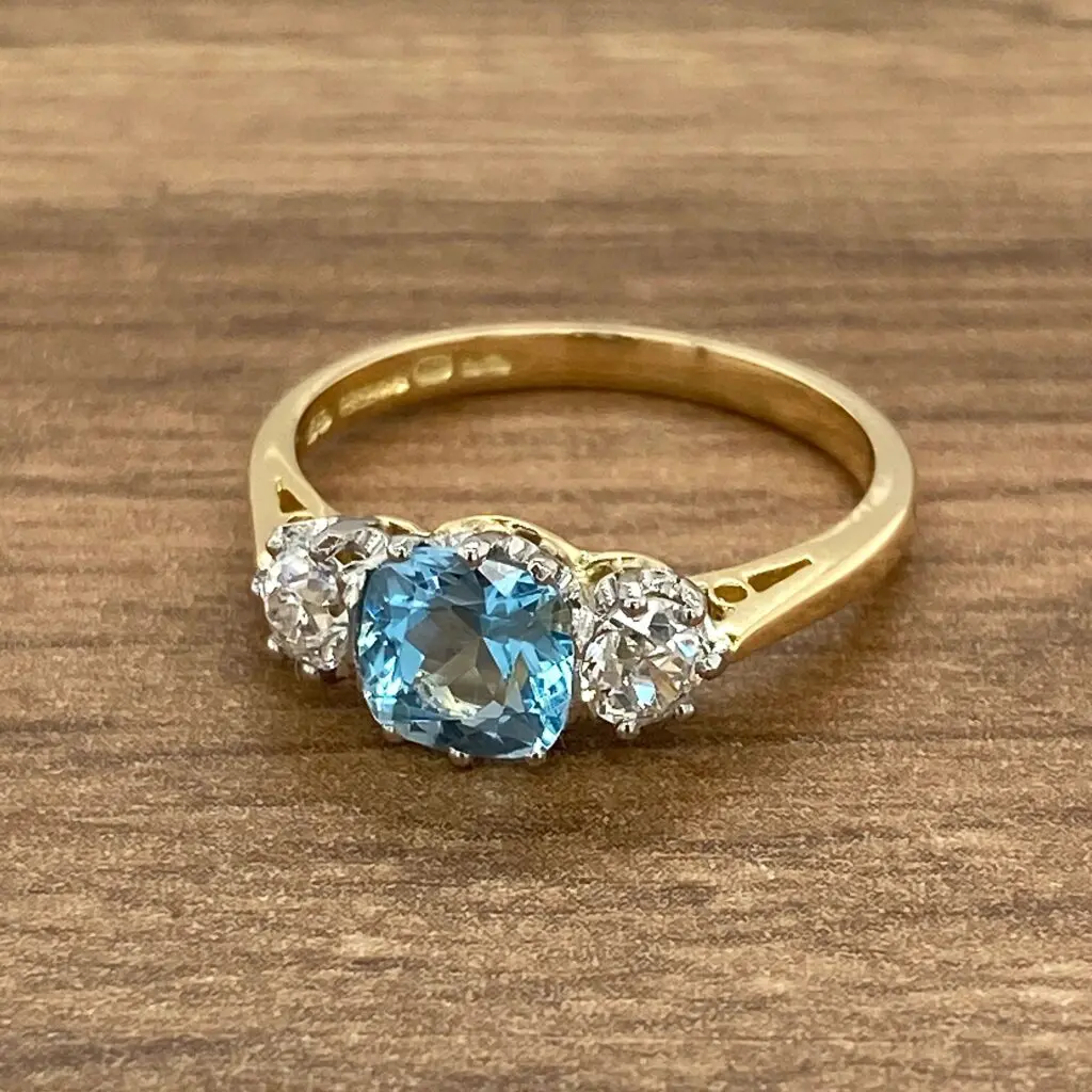 Gold ring with blue and white stones.